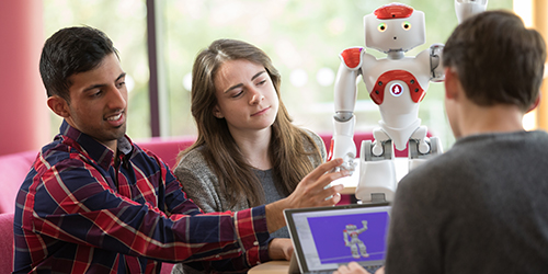 Three students using a robot together. 